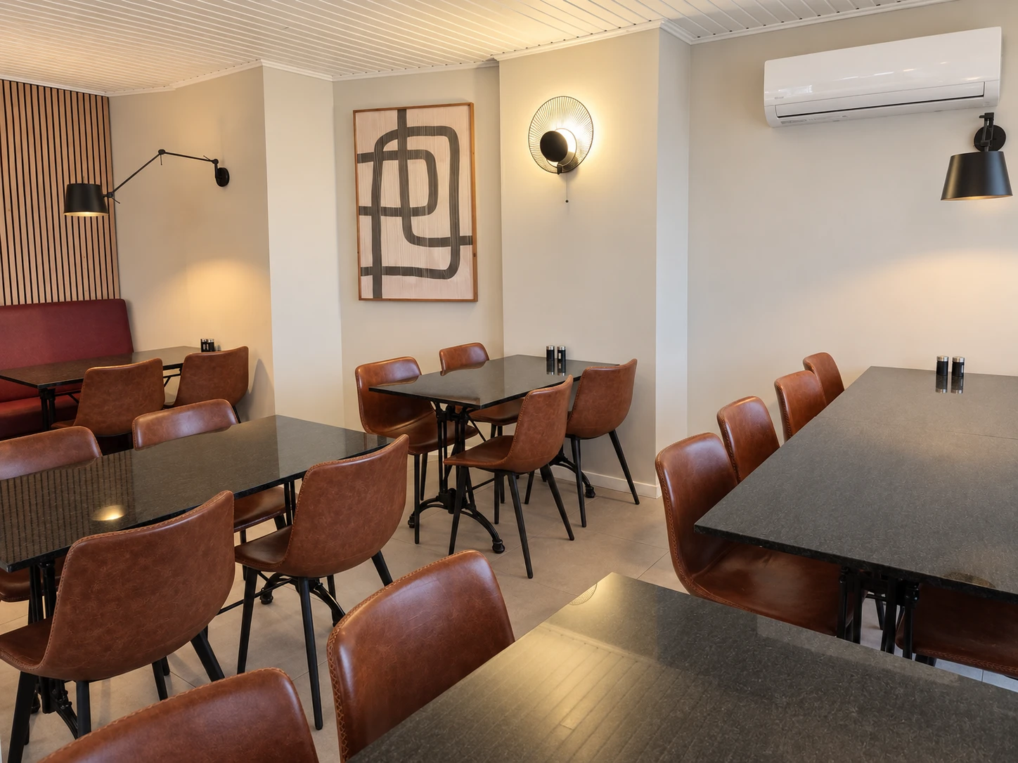 Ons gezellige zitgedeelte met warme verlichting en bruine stoelen